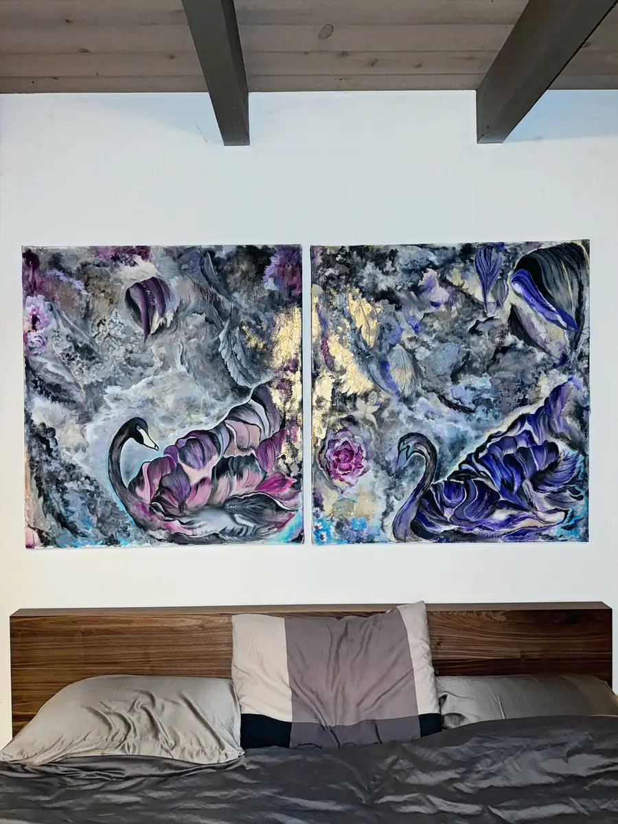 A commissioned diptych of swans hanging above a bed