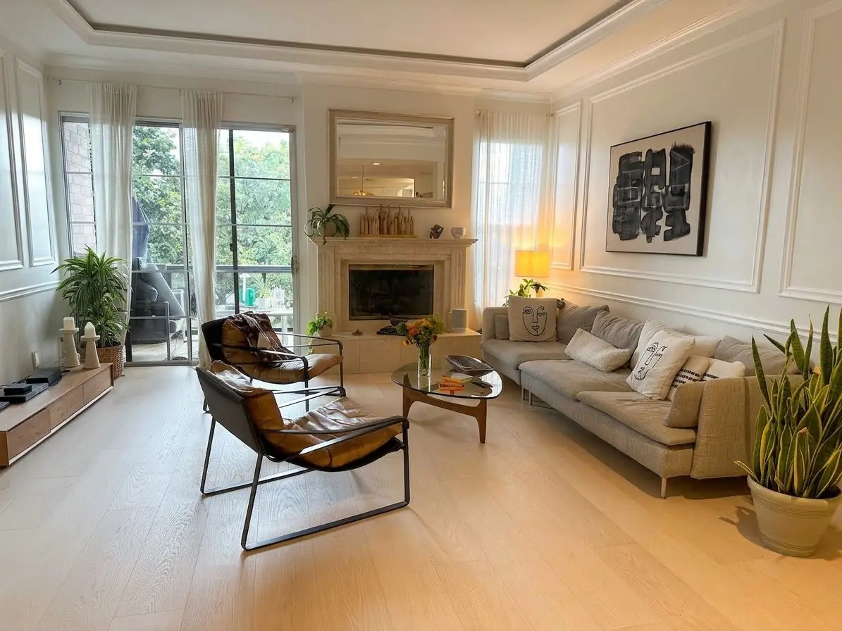 A bright living room with large windows and a fireplace