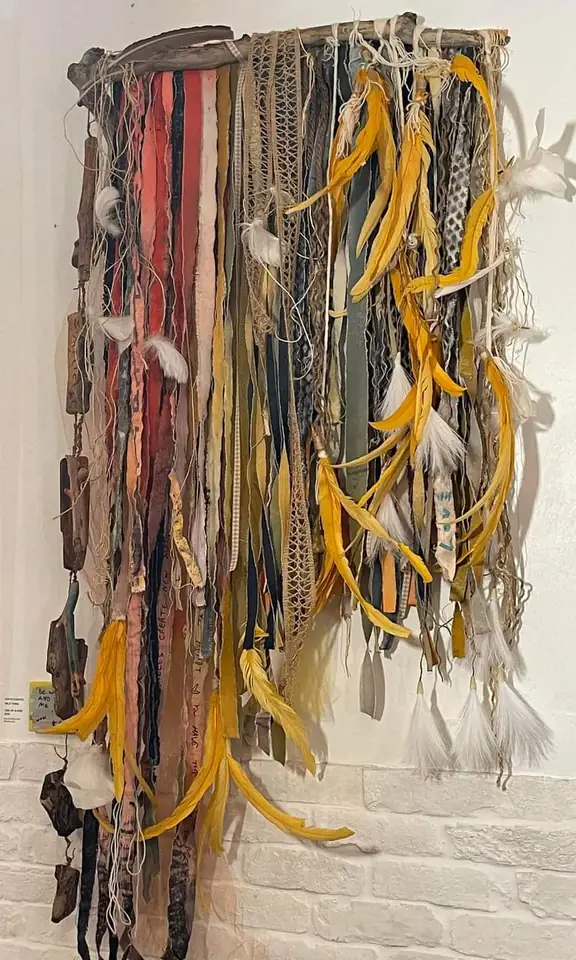 Wild Thing: a tall wall hanging of painted fabric strips, cords and yellow feathers